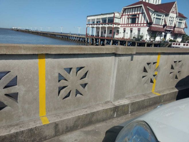 Pintura de fajas amarillas en el murallón de la playa para ayuda al estacionamiento